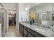 Modern bathroom featuring dual sinks, granite countertops, a glass shower, and a walk-in closet at 2503 Yellow Brick Rd, St Cloud, FL 34772