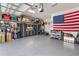 Spacious garage featuring ample storage solutions, a tool bench, and an American flag at 2503 Yellow Brick Rd, St Cloud, FL 34772