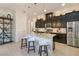 Modern kitchen featuring an island with bar seating, stainless appliances, and dark cabinets at 2503 Yellow Brick Rd, St Cloud, FL 34772