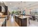 Spacious kitchen with island, connecting to a living room and a dining area under pendant lights at 2503 Yellow Brick Rd, St Cloud, FL 34772