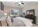 Bright main bedroom featuring a tray ceiling, ceiling fan, and large windows for ample natural light at 2503 Yellow Brick Rd, St Cloud, FL 34772