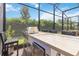 Spacious outdoor bar area with stainless steel appliances and barstool seating within a screened patio enclosure at 2503 Yellow Brick Rd, St Cloud, FL 34772