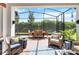 Relaxing screened patio with brick flooring, wicker furniture, and an outdoor dining area overlooking the manicured backyard at 2503 Yellow Brick Rd, St Cloud, FL 34772
