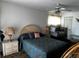 Bedroom featuring a patterned comforter, end tables with lamps, and ceiling fan at 2659 Crown Ct # 11, Kissimmee, FL 34741