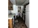 Galley kitchen with wooden cabinets, white appliances, and bathroom in back at 2659 Crown Ct # 11, Kissimmee, FL 34741