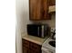 Black microwave oven on countertop between the stove and dark brown cabinets at 2659 Crown Ct # 11, Kissimmee, FL 34741
