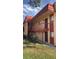 Side exterior view of a multi-Gathering residential building with red tile roof, balconies, and manicured hedges at 2804 N Powers Dr # 31, Orlando, FL 32818