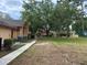 Backside of the community building with a large green space, mature shade trees, and a sidewalk at 2804 N Powers Dr # 31, Orlando, FL 32818