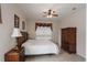 Tiled bedroom featuring wardrobe with drawers, ceiling fan, window, and bedside tables and lamps at 301 Rosso Dr, Davenport, FL 33837