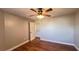 Bedroom featuring wood-look floors, ceiling fan, and a view into an ensuite bathroom at 3038 Parkway Blvd # 204, Kissimmee, FL 34747
