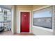 Exterior view of a red front door with a security knocker and a window with blinds at 3038 Parkway Blvd # 204, Kissimmee, FL 34747