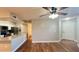 Inviting living room with wood floors, ceiling fan, view to the kitchen and bathroom access at 3038 Parkway Blvd # 204, Kissimmee, FL 34747