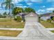 Charming single-story home with a two-car garage, mature landscaping, and basketball hoop at 3160 Santa Cruz Dr, Kissimmee, FL 34746