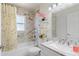 Bathroom featuring marble tile, decorative mirror, and tub with shower at 318 Highland Meadows Dr, Davenport, FL 33837