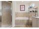 Bright bathroom featuring a separate shower, soaking tub and tiled surround at 318 Highland Meadows Dr, Davenport, FL 33837
