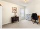 Minimalist bedroom featuring neutral colored carpet and walls, complete with a decorative dresser and modern office chair at 318 Highland Meadows Dr, Davenport, FL 33837