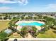 Aerial shot of a large community pool area surrounded by lush palm trees and ample lounging space at 318 Highland Meadows Dr, Davenport, FL 33837