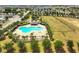 Community pool with ample seating, shade, and a playground set against a beautiful green neighborhood backdrop at 318 Highland Meadows Dr, Davenport, FL 33837