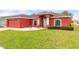 Charming exterior showcasing a well-manicured lawn and a vibrant red facade at 318 Highland Meadows Dr, Davenport, FL 33837