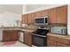 Well-lit kitchen boasts stainless steel appliances, granite countertops, and wood cabinetry at 318 Highland Meadows Dr, Davenport, FL 33837