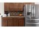 Kitchen features stainless steel refrigerator, granite countertops, and mosaic tile backsplash at 318 Highland Meadows Dr, Davenport, FL 33837
