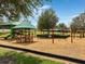 Community playground featuring covered play structures, swings, and benches for enjoyment and recreation at 318 Highland Meadows Dr, Davenport, FL 33837