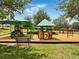Community playground featuring covered play structures, swings, and benches for enjoyment and recreation at 318 Highland Meadows Dr, Davenport, FL 33837