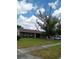 Traditional brick home with a lush green lawn, mature trees, and a welcoming front porch at 3231 Lowndes Dr, Winter Park, FL 32792