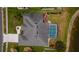 An aerial shot showcasing the home's roof, screened pool, landscaping, and proximity to a pond at 3256 Countryside View Dr, St Cloud, FL 34772