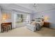 Bright bedroom featuring a tray ceiling, a ceiling fan, and a large window at 3256 Countryside View Dr, St Cloud, FL 34772
