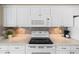 Bright kitchen features white cabinets, tile backsplash, and stainless steel appliances at 3256 Countryside View Dr, St Cloud, FL 34772