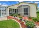 Landscaped backyard featuring colorful flowers and decorative rocks surrounding the screened-in patio and pool area at 3256 Countryside View Dr, St Cloud, FL 34772