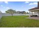 Spacious backyard featuring a well-maintained lawn, white fence, and covered patio area for outdoor relaxation at 3366 Puxton Dr, Orlando, FL 32824