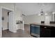 Partial view of a kitchen and open floor plan with dark cabinets and wood-look floors, showcasing the layout at 3366 Puxton Dr, Orlando, FL 32824