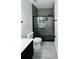 Modern bathroom with a glass-enclosed shower featuring gray tiling and black fixtures at 3426 Wilshire Way Rd # 189, Orlando, FL 32829