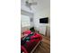 This bedroom features hardwood floors, a ceiling fan, TV and desk with a window view at 3426 Wilshire Way Rd # 189, Orlando, FL 32829