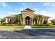 A view of the community clubhouse with lush landscaping and elegant entryway at 3426 Wilshire Way Rd # 189, Orlando, FL 32829