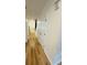 Hallway view with wood-look flooring and white doors, leading towards the home's entry and second level at 3426 Wilshire Way Rd # 189, Orlando, FL 32829