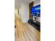 Hallway view showcasing light wood floors that extend to the front door, accent wall, and modern entertainment center at 3426 Wilshire Way Rd # 189, Orlando, FL 32829