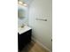 Elegant powder room featuring a black vanity, gold fixtures, and a modern circular mirror at 3426 Wilshire Way Rd # 189, Orlando, FL 32829
