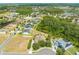 Property set among trees, with neighboring homes and community features in the background at 3551 Buckingham Ct, St Cloud, FL 34772