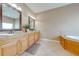 Bathroom featuring dual vanities, granite countertops, and a soaking tub at 3551 Buckingham Ct, St Cloud, FL 34772