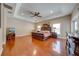Spacious main bedroom with a tray ceiling, hardwood floors, and ample natural light at 3551 Buckingham Ct, St Cloud, FL 34772