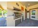 This outdoor kitchen features stainless steel appliances, a built-in grill, and a mini-fridge, perfect for backyard entertaining at 3551 Buckingham Ct, St Cloud, FL 34772