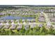 An aerial view showcases a neighborhood with a pond and meticulously landscaped homes at 3881 Wind Dancer Cir, St Cloud, FL 34772