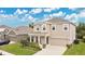Beautiful two-story home with a manicured lawn, complemented by a driveway and lush greenery at 3881 Wind Dancer Cir, St Cloud, FL 34772