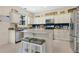 Kitchen featuring white cabinets, stainless steel appliances, a center island with bar stools, and stylish decor at 3881 Wind Dancer Cir, St Cloud, FL 34772