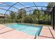 Screened-in pool area with a view of the lush backyard at 3881 Wind Dancer Cir, St Cloud, FL 34772