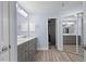 Spacious bathroom featuring gray double vanity, modern fixtures, tile floor, large mirror and walk-in shower at 404 N Sundance Dr, Lake Mary, FL 32746