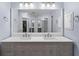 Bright bathroom with double sink vanity, quartz countertop, gray cabinetry and a large mirror at 404 N Sundance Dr, Lake Mary, FL 32746